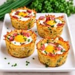 Nids de pommes de terre aux oeufs et bacon sur assiette blanche.
