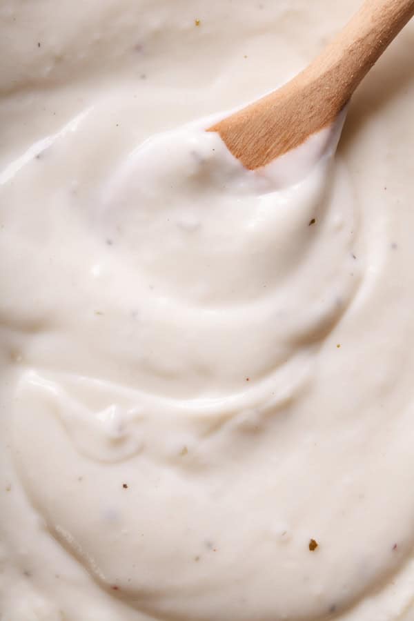 Sauce béchamel avec une cuillère en bois.