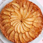 Gâteau aux pommes caramélisées sur assiette blanche.